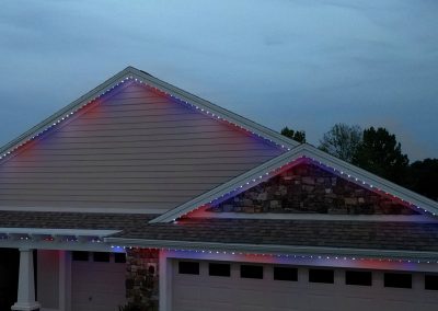 Permanent Trimlight roofline lighting in red, white and blue on a home in The Villages, Florida